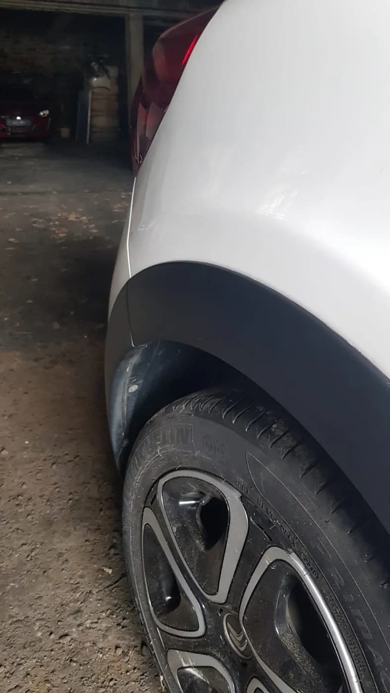 Après — aile arrière d'une citadine blanche, enfoncement effacé sans peinture